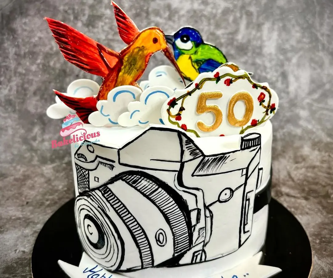 A truly unique, all-edible hand-painted cake created for a wildlife photographer's 50th birthday. The comic-style camera and colourful birds on top showcase my passion for turning your hobbies into delicious art.