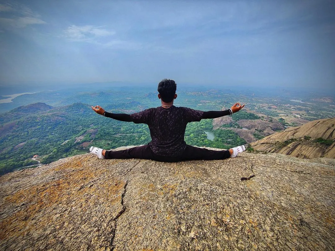 Finding balance and stillness with Samakonasana at the peak of Savanadurga hill. Reaching the summit of a trek is not just a physical achievement; it is a chance to connect with the vastness around you and the stillness within. This is a moment of pure presence.