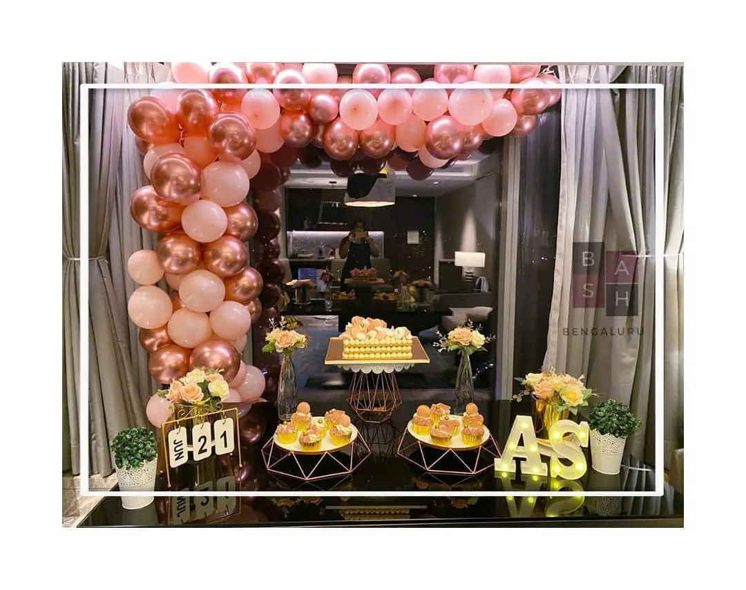Celebrate your milestones in style with a grand and glamorous setup. This anniversary decoration features a stunning rose gold and pink balloon arch, a fully styled dessert table, and personalized marquee letters, creating a spectacular backdrop for your special day.