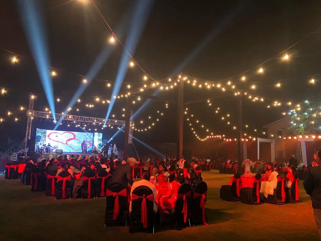 Let's get the party started with a sangeet night to remember. We transformed this outdoor lawn in Lonavala with dramatic stage lighting, a large LED screen for performances, and cozy string lights to create a festive atmosphere perfect for an evening of *nacho tappo*.