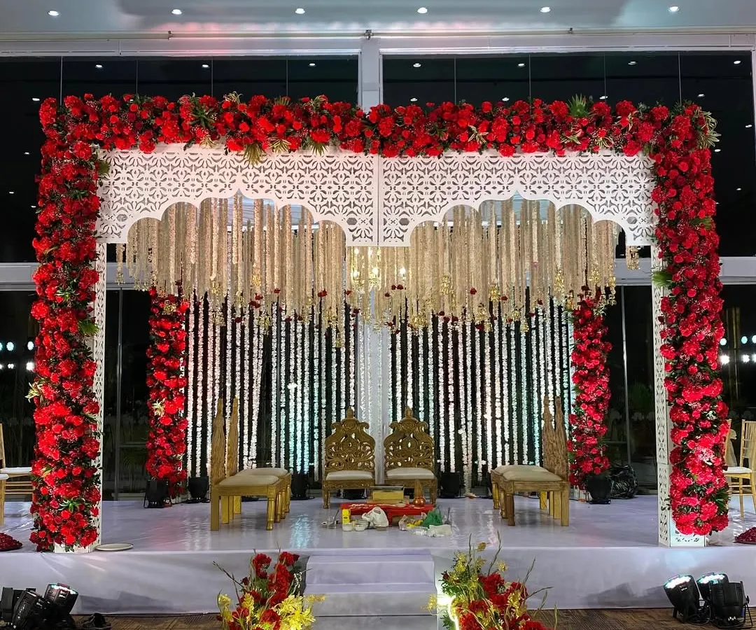We believe in the timeless power of tradition. This magnificent mandap, framed by a rich arch of red roses and adorned with delicate white floral strings, creates a sacred and visually stunning space for wedding vows.