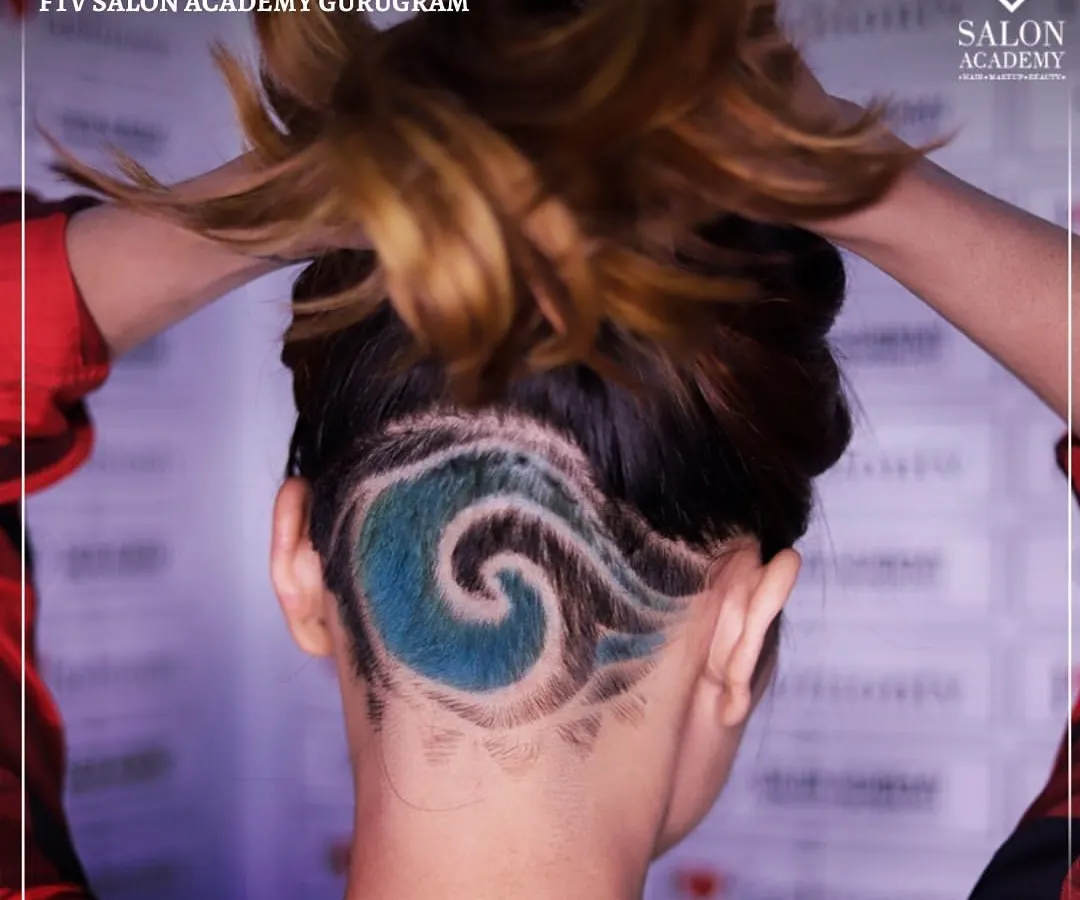 We push creative boundaries in our hair courses. This student's work features an intricate undercut with a vibrant blue wave design, showcasing advanced clipper techniques and creative hair coloring skills.