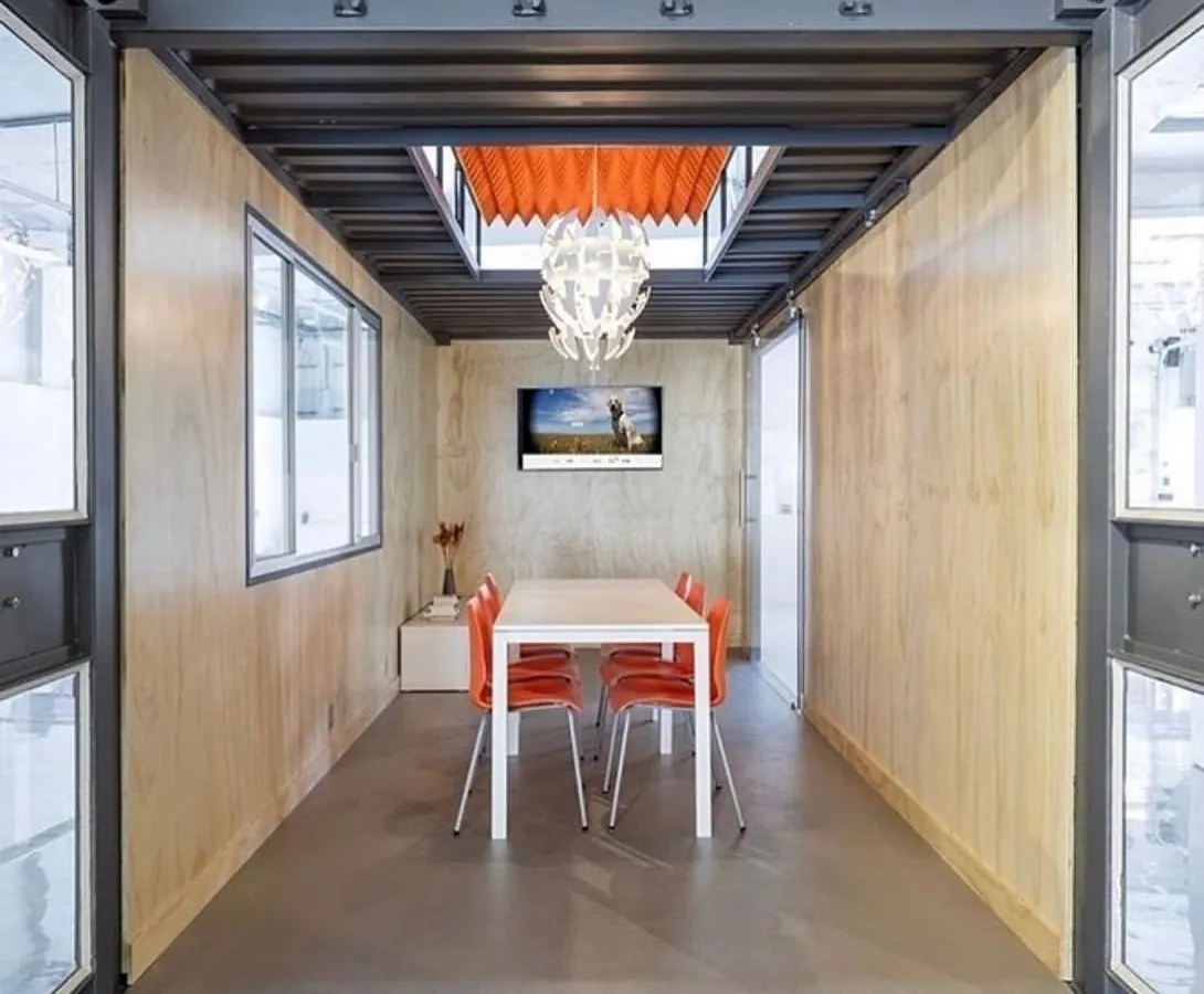 We transform industrial containers into sophisticated work environments. This meeting room showcases our attention to modern design, with clean lines, natural light from a custom skylight, and all the integrated technology needed for a productive business hub.
