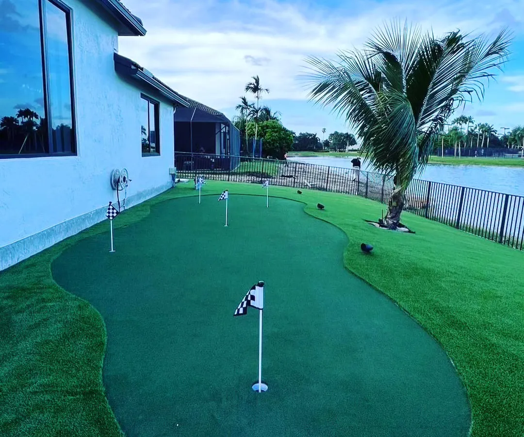 This backyard putting green was designed to fit the long space next to the house, overlooking the water. It features multiple holes for varied putting practice.