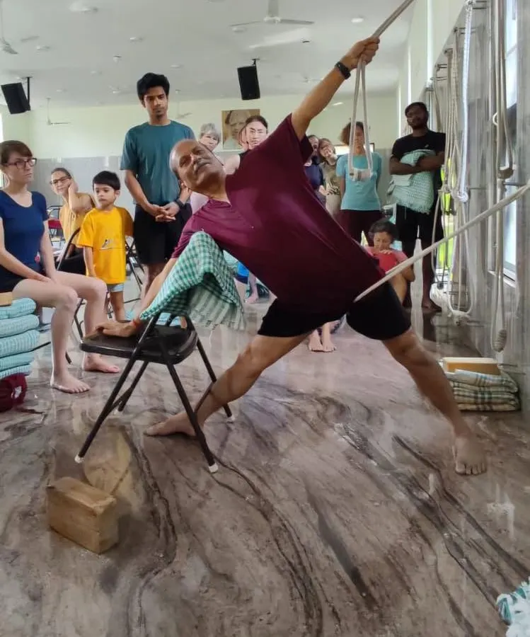 Here, I demonstrate Utthita Trikonasana (Triangle Pose) using a chair and ropes. This showcases the Iyengar method's use of props to achieve precise alignment and a deeper understanding of the asana's mechanics.