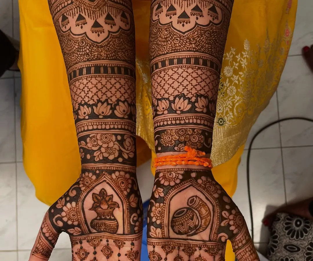 A complete view of a traditional bridal mehendi design. The symmetrical patterns extend up to the elbows, featuring classic motifs like kalash pots, elephants, and lotuses for a grand and timeless look.