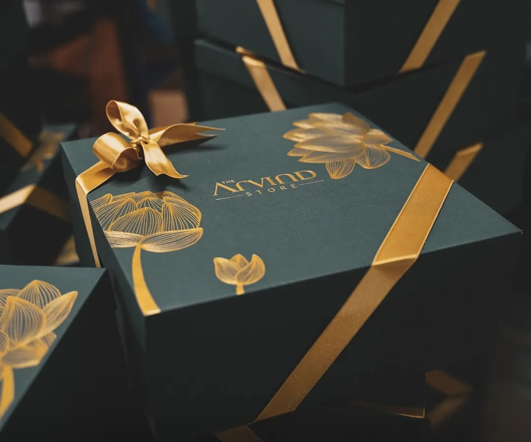We excel in creating bespoke corporate gifts that reflect your brand's elegance. Here is a custom-designed luxury hamper for Arvind Store, featuring deep green boxes with gold foil and satin ribbons for a truly premium feel.