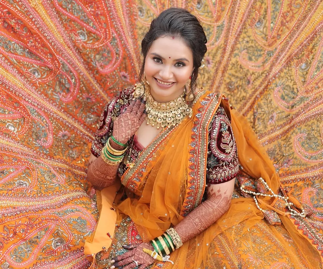 A true queen in her magnificent orange and maroon lehenga. For this bridal look, we went for a classic radiant face with defined eyes to complement the grandeur of her outfit.