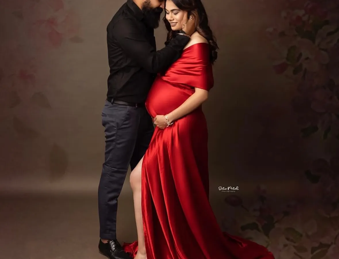 Capture the passion and intimacy of your journey with our bold red satin mermaid gown. Its vibrant color and sleek fit beautifully highlight your baby bump, making for powerful and romantic couple portraits.