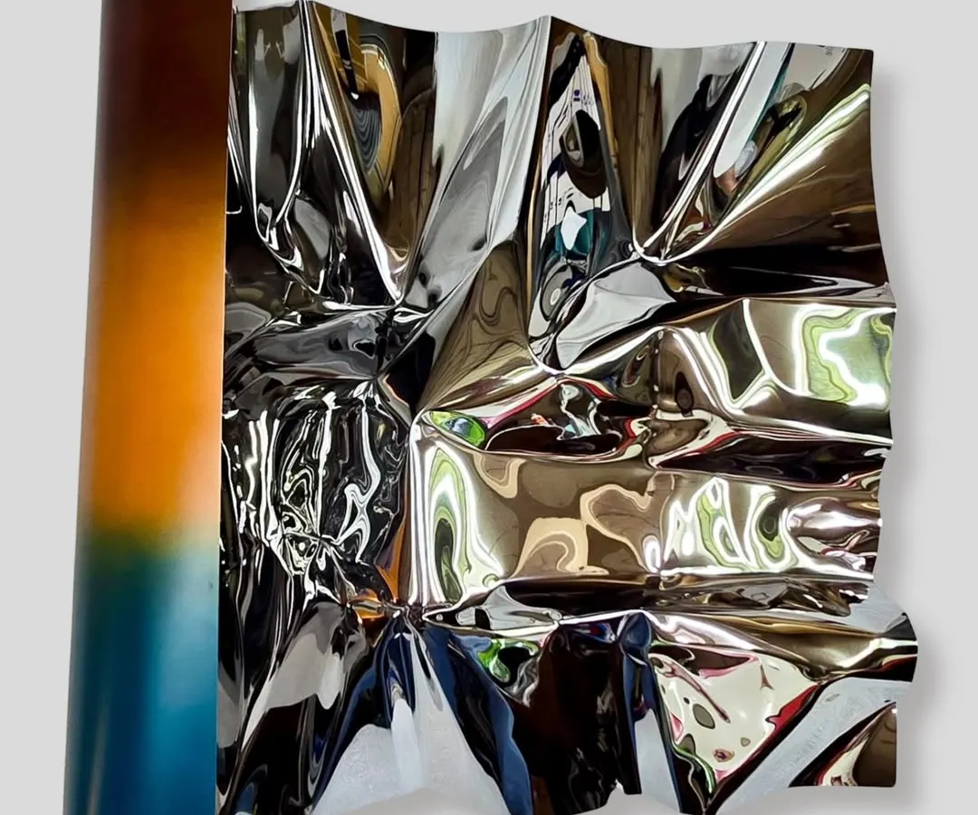 I call this series 'Meteor,' where I work to make rigid stainless steel feel fluid and alive. This wall installation, Meteor 151, uses a color gradient to capture the warmth of a sunset, with the polished surface constantly playing with light and reflection.
