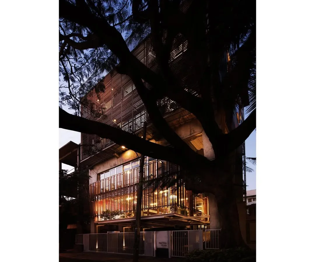 My own studio at dusk, conceived as a translucent lantern framed by a mature rain tree. The design is an honest expression of its structure, with three robust concrete portals supporting suspended galleries. It is a living example of my belief in open, evolving spaces that foster creativity.