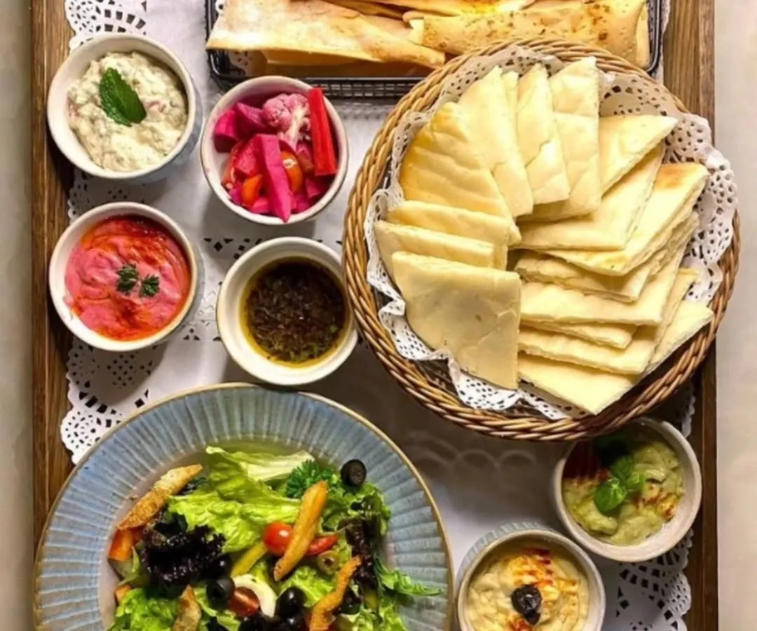 My classic Mezze Platter is a journey to the Mediterranean. It includes creamy, homemade hummus and other dips, crispy falafel, pickled vegetables, fresh salad, and warm pita bread, all arranged and ready to serve.