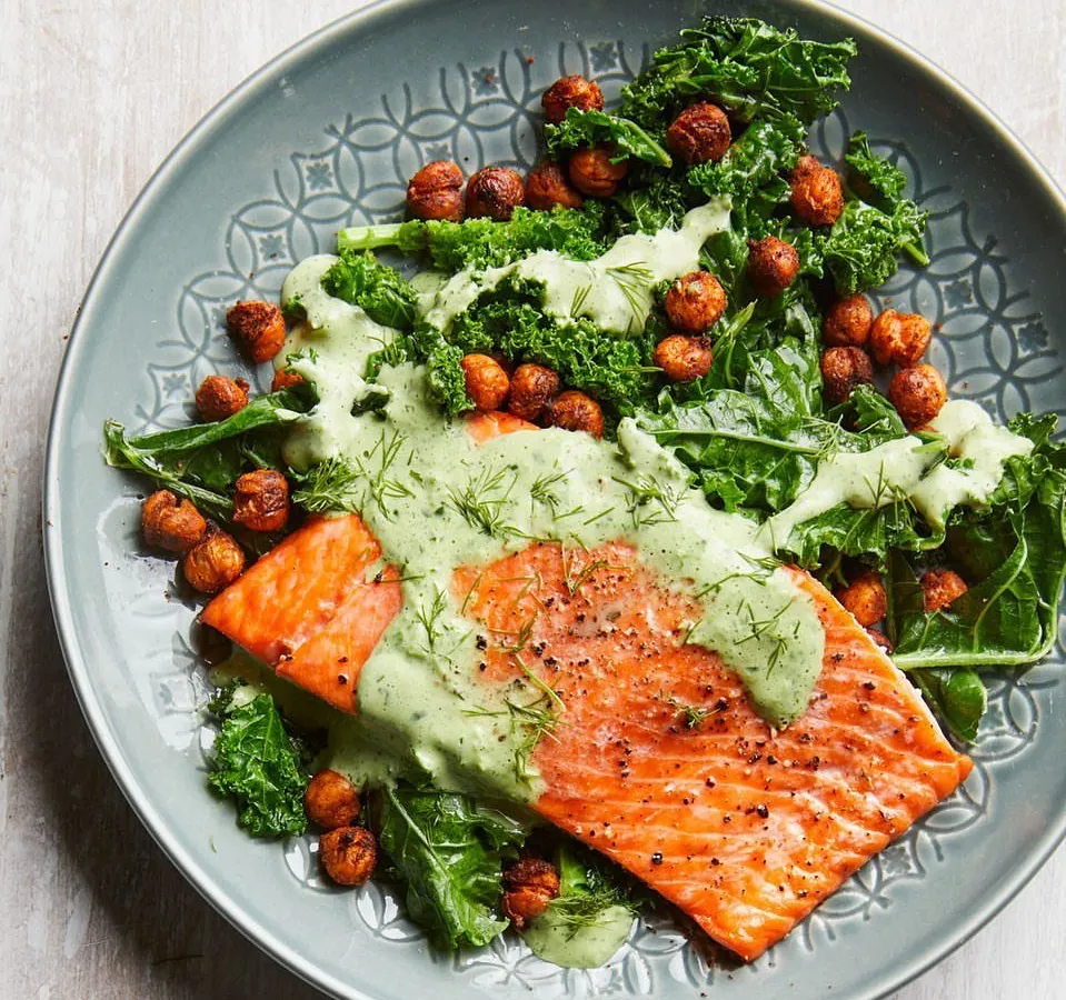 A perfectly cooked salmon fillet on a bed of fresh kale and roasted chickpeas, topped with a creamy dill sauce. This is an example of my premium non-vegetarian meals, rich in Omega-3s and designed for clean eating.