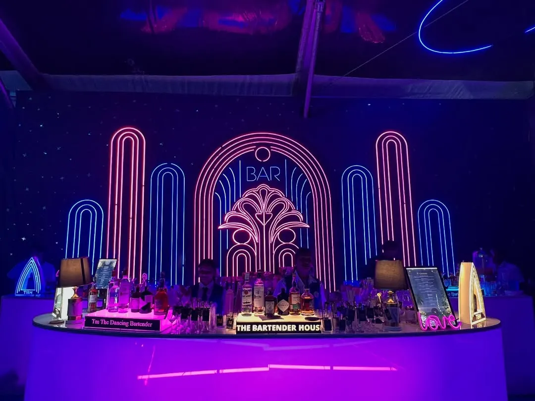 We believe the bar should be a masterpiece. Here’s a look at one of our stunning Art Deco-inspired neon bar setups, designed to be the glowing heart of your celebration.
