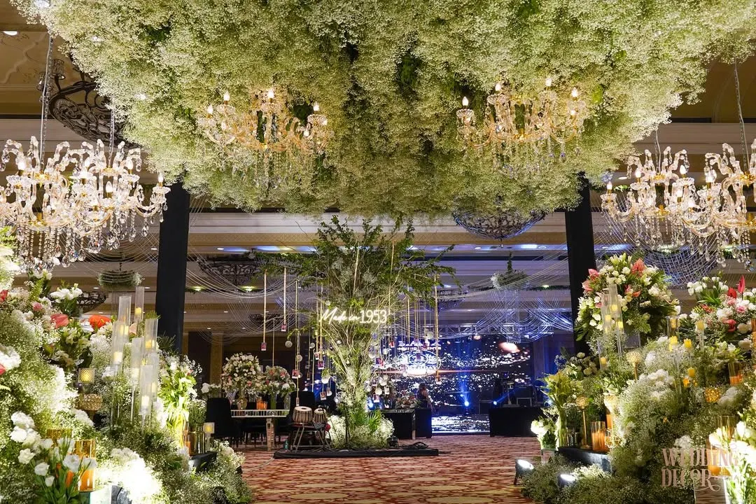 For a 70th birthday, I designed this breathtaking entrance under a canopy of baby's breath and sparkling chandeliers. It was about creating a heavenly, dream-like passage to celebrate a life filled with beautiful moments.