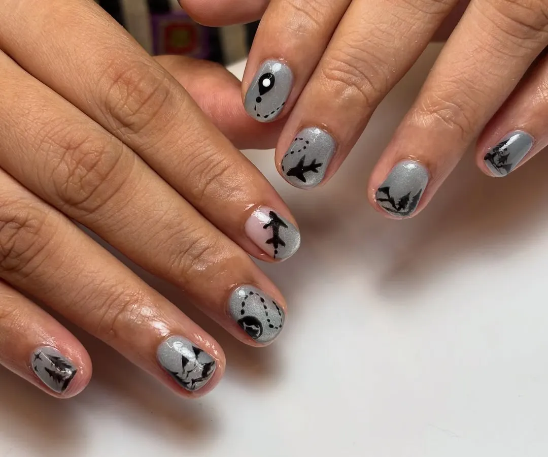 This client was heading to Switzerland and wanted her nails to tell the story. I hand-painted tiny airplanes, mountain silhouettes, and map routes on a cool grey base to capture her travel excitement.