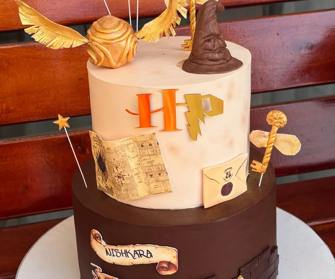 For the ultimate Potterhead, we designed this magical two-tier Harry Potter cake. It's packed with iconic, handmade fondant details like the Sorting Hat, Golden Snitch, and a letter from Hogwarts, making it a truly enchanting centerpiece.
