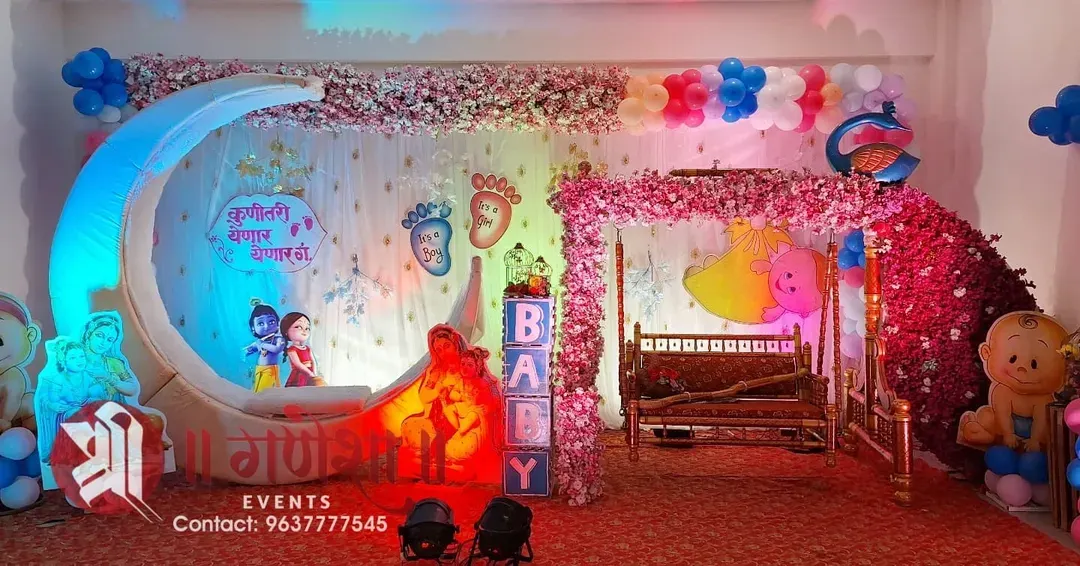This is one of my favorite Dohale Jevan setups. It features a large crescent moon prop, a beautifully decorated swing, and a special Marathi sign saying 'कुणीतरी येणार येणार' to welcome the little one.