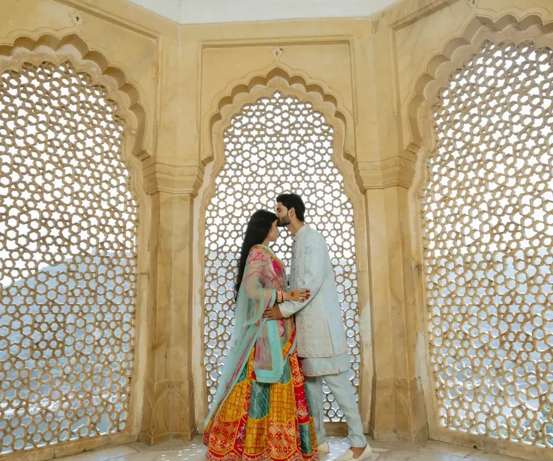 Inside the historic walls of Amber Fort, I use the intricate jali windows to frame your connection. It’s about finding those quiet, intimate moments amidst the royal splendor, creating a timeless portrait of your love.