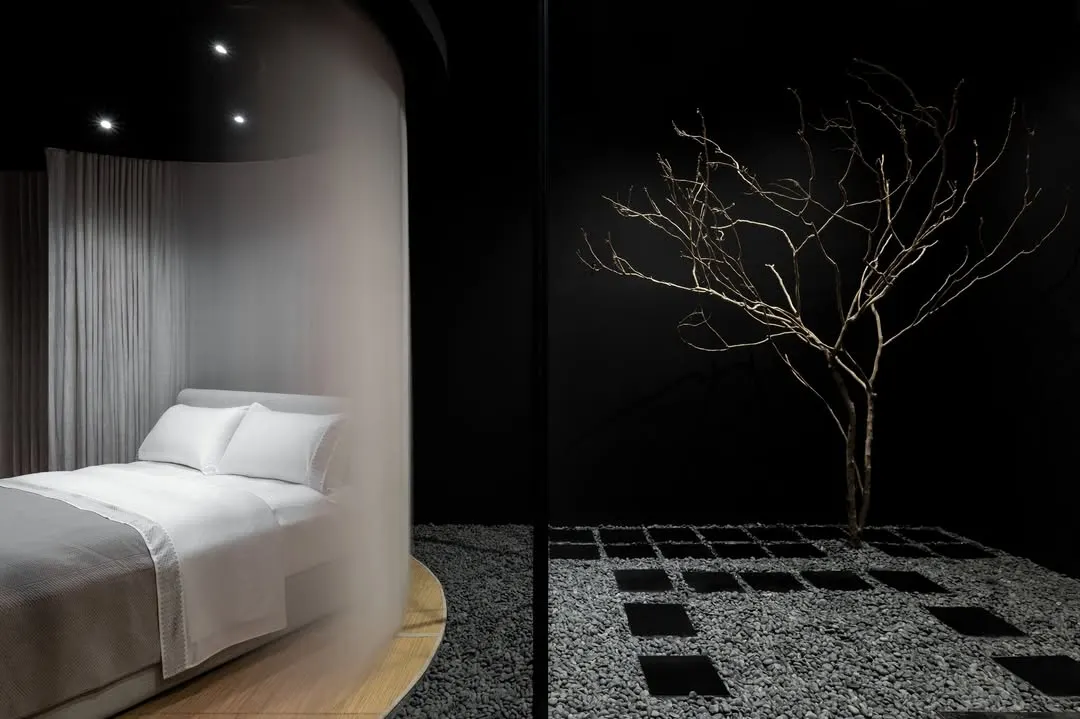 This composition illustrates our core concept of discovery. The product, a finely dressed bed, is partially revealed through a translucent veil, juxtaposed with the sculptural, organic form of a bare tree at the entrance, blending the commercial purpose with a natural, calming aesthetic.