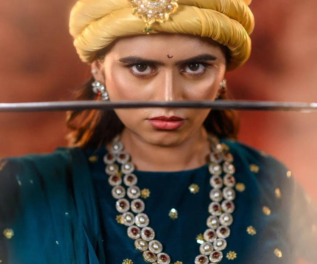 It's more than a costume; it's about embodying a character. Here, we capture the fierce intensity of Rani Lakshmibai, with a focus on the determined expression, period-accurate pagri, and the powerful presence of the warrior queen.