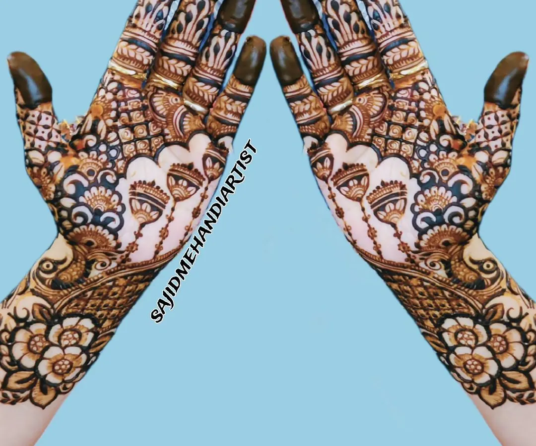 A classic, full-hand mehandi design perfect for a wedding guest. The pattern is symmetrical and packed with detail, featuring traditional floral and paisley motifs that extend up the wrist for a rich, complete look.