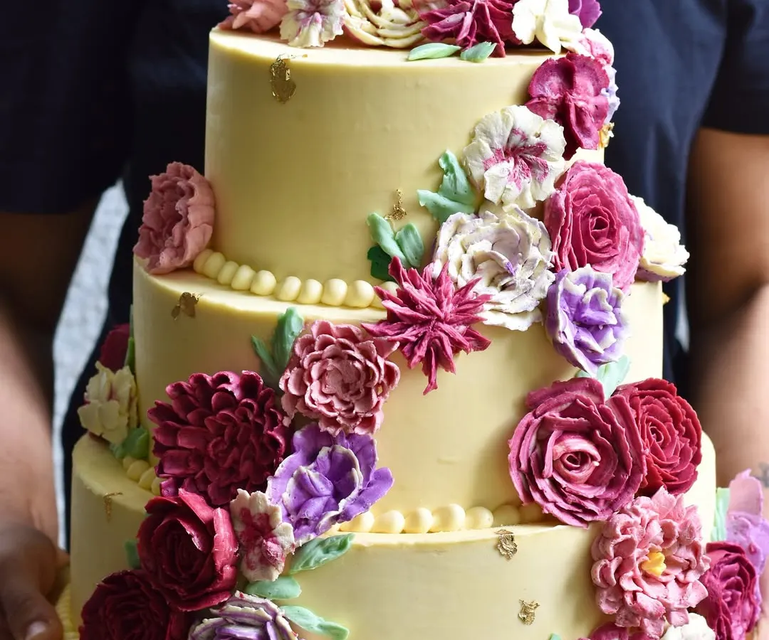 This three-tiered beauty, adorned with a cascade of hand-piped buttercream flowers, is a perfect example of our custom celebration cakes. We work with you to create a stunning, delicious centerpiece for your wedding or special occasion, completely free of fondant.