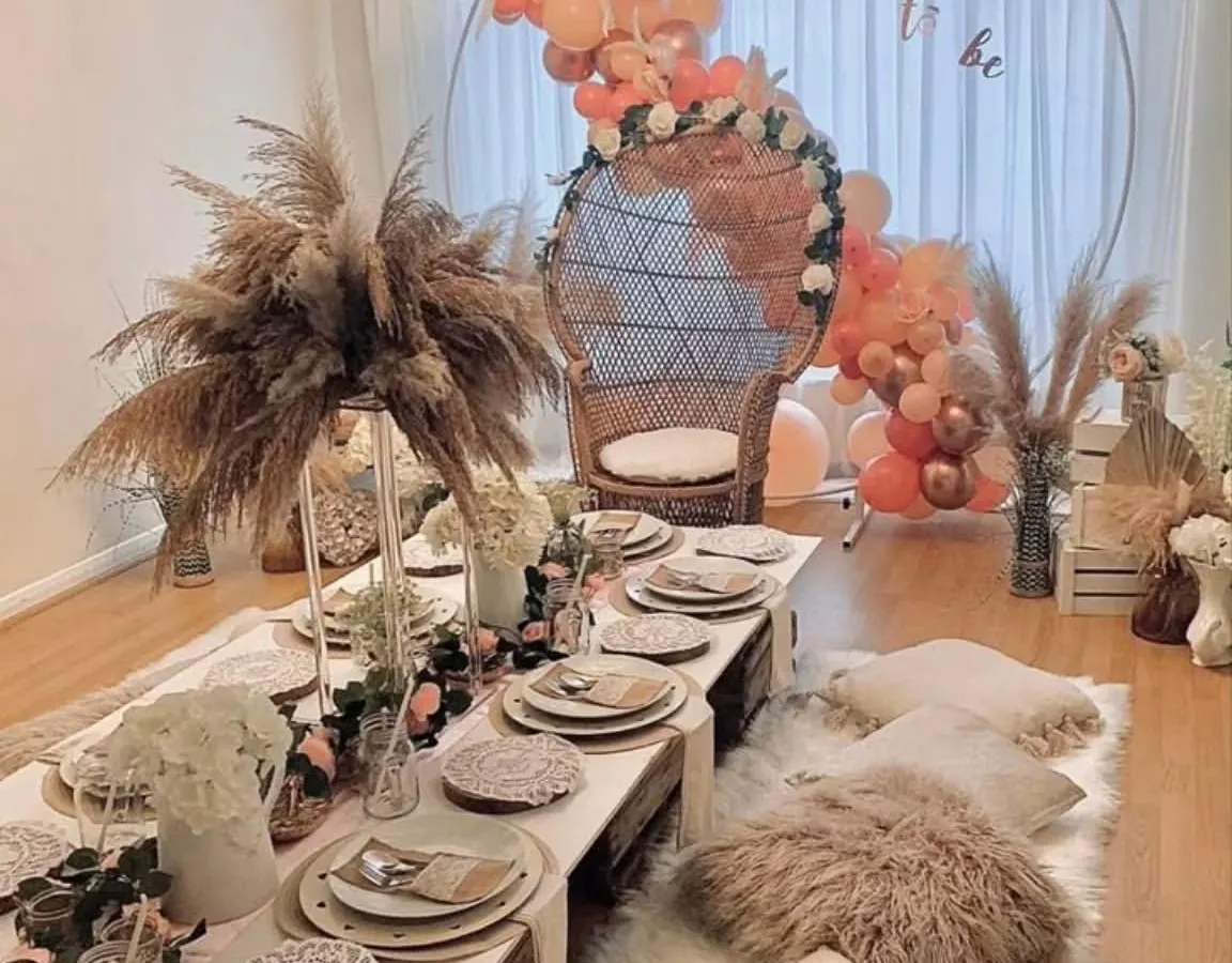 A look at our boho-chic bridal shower setup, designed to be effortlessly beautiful. We combine low wooden tables, plush floor cushions, and arrangements of pampas grass with a statement wicker chair for the bride-to-be, creating a picture-perfect celebration.