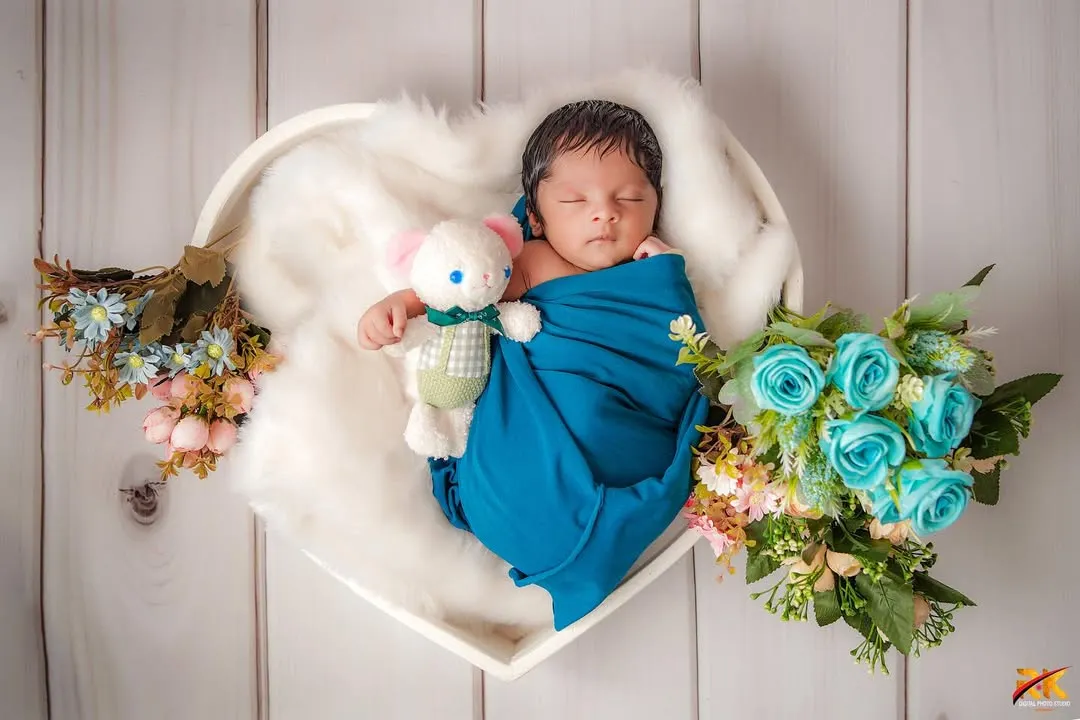 There is nothing more pure than a sleeping newborn. For this portrait, I used a heart-shaped basket and soft white fur to gently cradle the baby, creating a timeless image of peace and new love.
