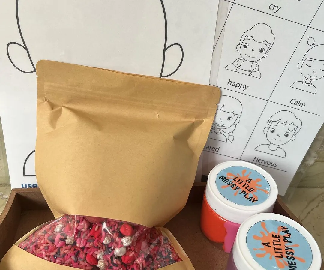 Here is a look at our complete handmade Valentine's sensory kit. It includes a bag of our taste-safe colored rice and pasta filler, two jars of our soft homemade playdough, and printed mats for learning about emotions.
