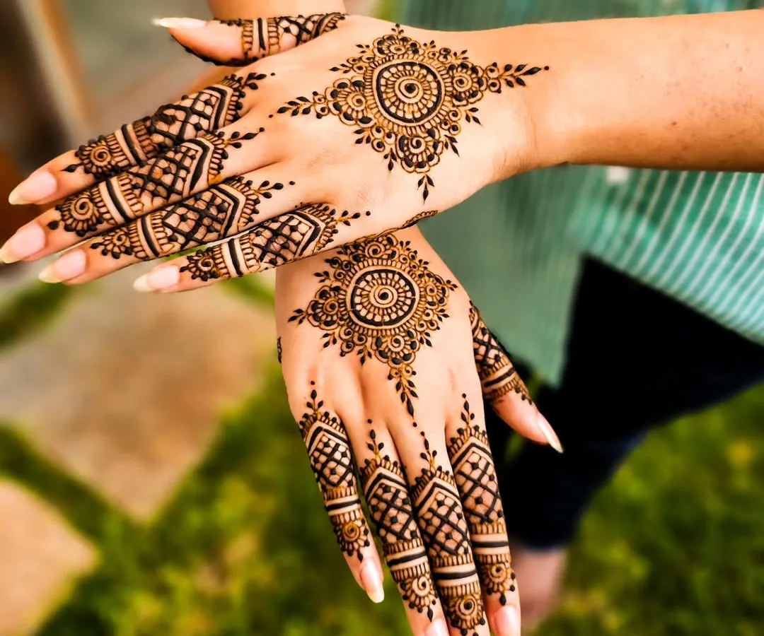 For the modern client who loves elegance, I create minimalist mehendi like this. The design focuses on a striking mandala on the back of the hand and geometric patterns on the fingers, leaving plenty of open space for a contemporary feel.