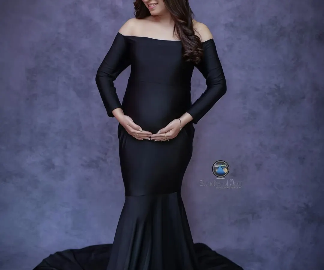 A solo maternity portrait can be incredibly powerful. Here, we used a classic off the shoulder black mermaid gown to create an elegant silhouette, highlighting the beautiful shape of her baby bump against a textured studio backdrop.