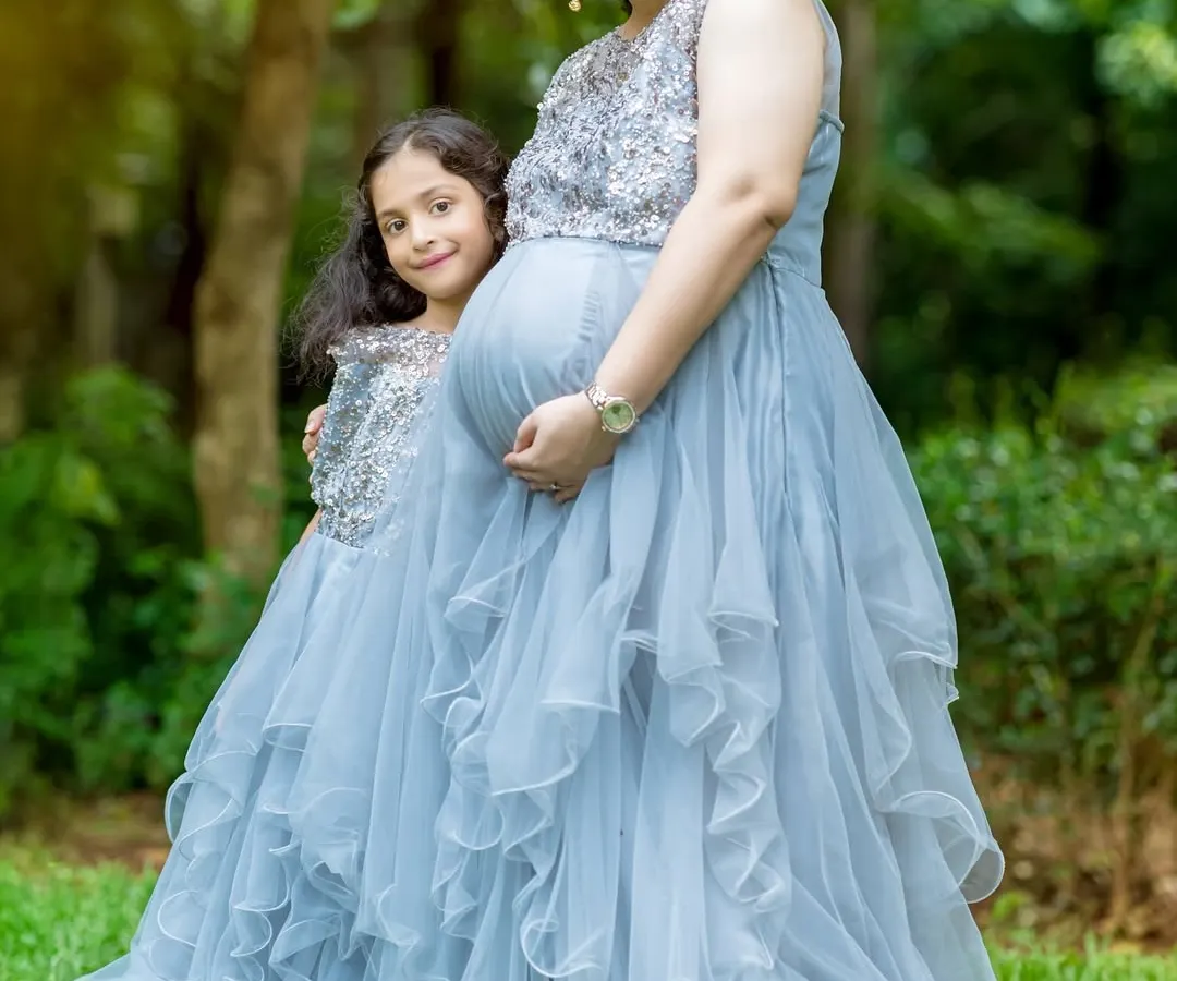 Celebrating with the whole family is so special. I offer matching mother and daughter gowns, like this beautiful grey ruffled set, to create truly memorable portraits that show the bond between a mother, her daughter, and the new baby on the way.