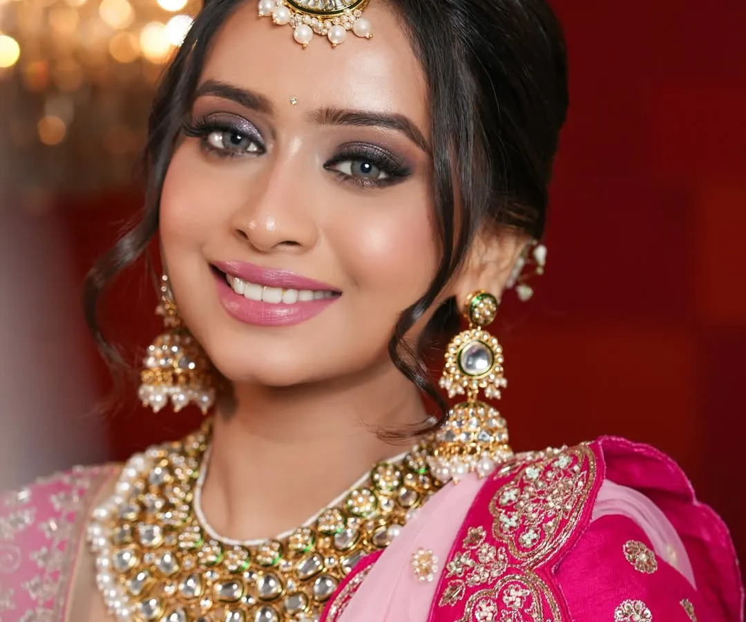 A classic bridal look is always timeless. Here, I created a soft yet defined smokey eye with a touch of sparkle, paired with a glowing skin finish and a beautiful pink lip to complement her stunning rani pink lehenga.