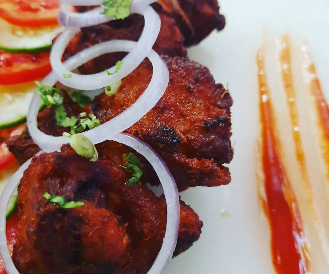 A close look at my B'luru Kebab. This is my take on the classic Bengaluru style chicken kebab, with its distinct red colour and incredibly tender texture. I serve it simply with fresh onion rings to let the flavour of the unique kebab marinade shine through.