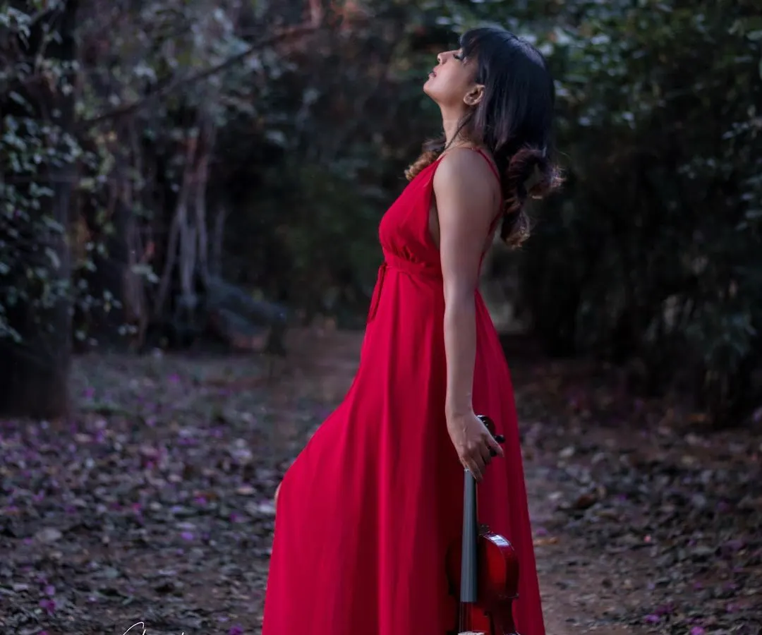 A 'woman in red' concept, set in a quiet, magical forest. This shot is all about creating a dreamy, painterly mood, where the vibrant dress stands out against the serene nature, telling a story without a single word.