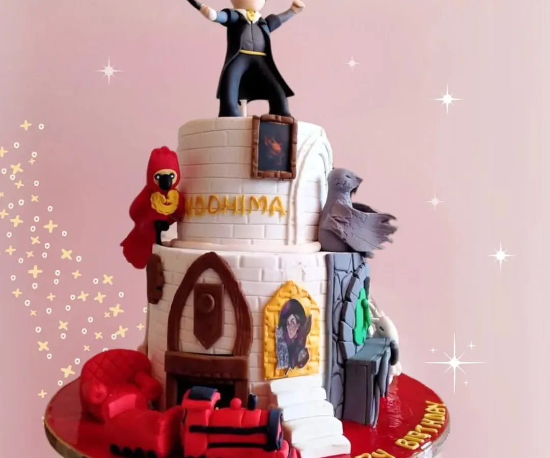 For the ultimate Harry Potter fan, this magical two-tier Hogwarts-themed cake features incredible fondant details, including a miniature Harry, Fawkes the phoenix, and the Hogwarts Express. It's a truly enchanting centerpiece for a magical birthday.