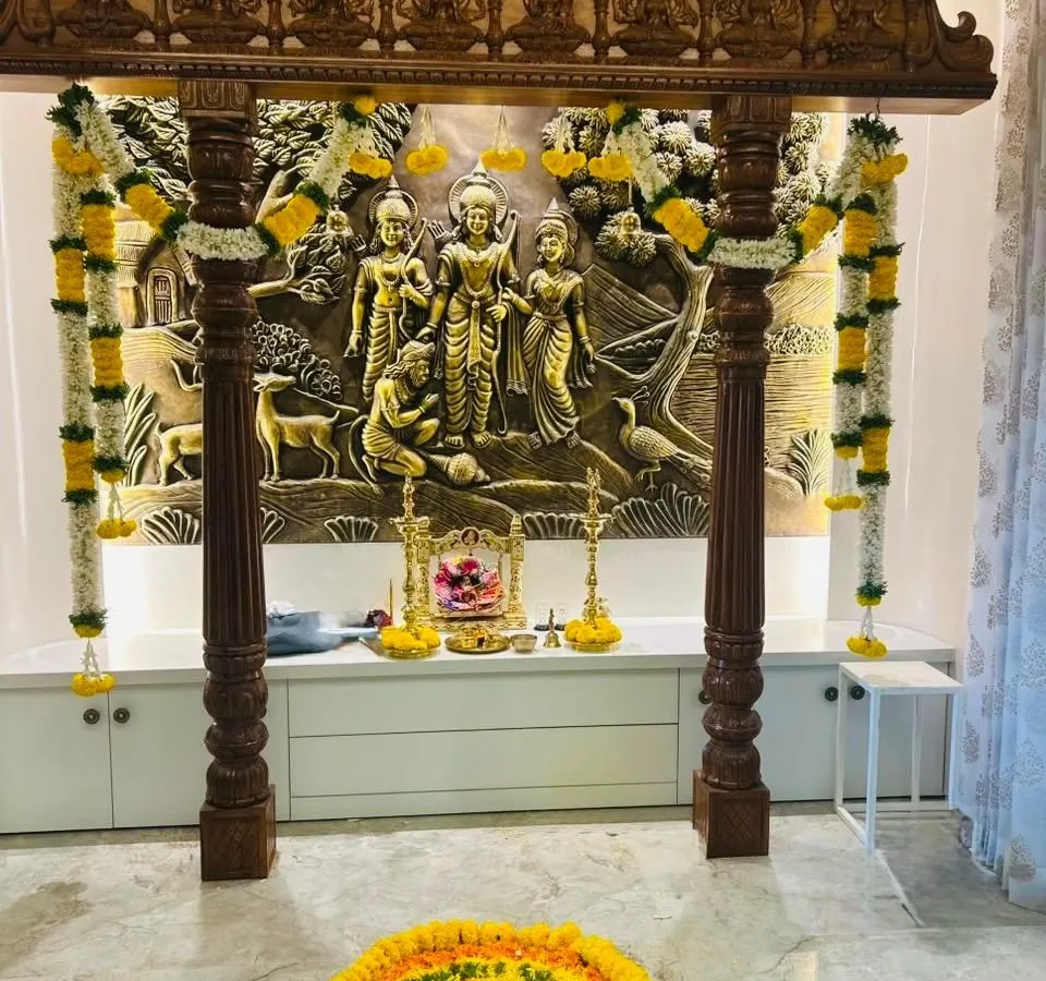 We set up the sacred pooja space for the housewarming ceremony, using traditional marigold and jasmine garlands to frame this beautiful wooden mandap. This pooja mandap decoration is designed to fill the new home with blessings. 💕