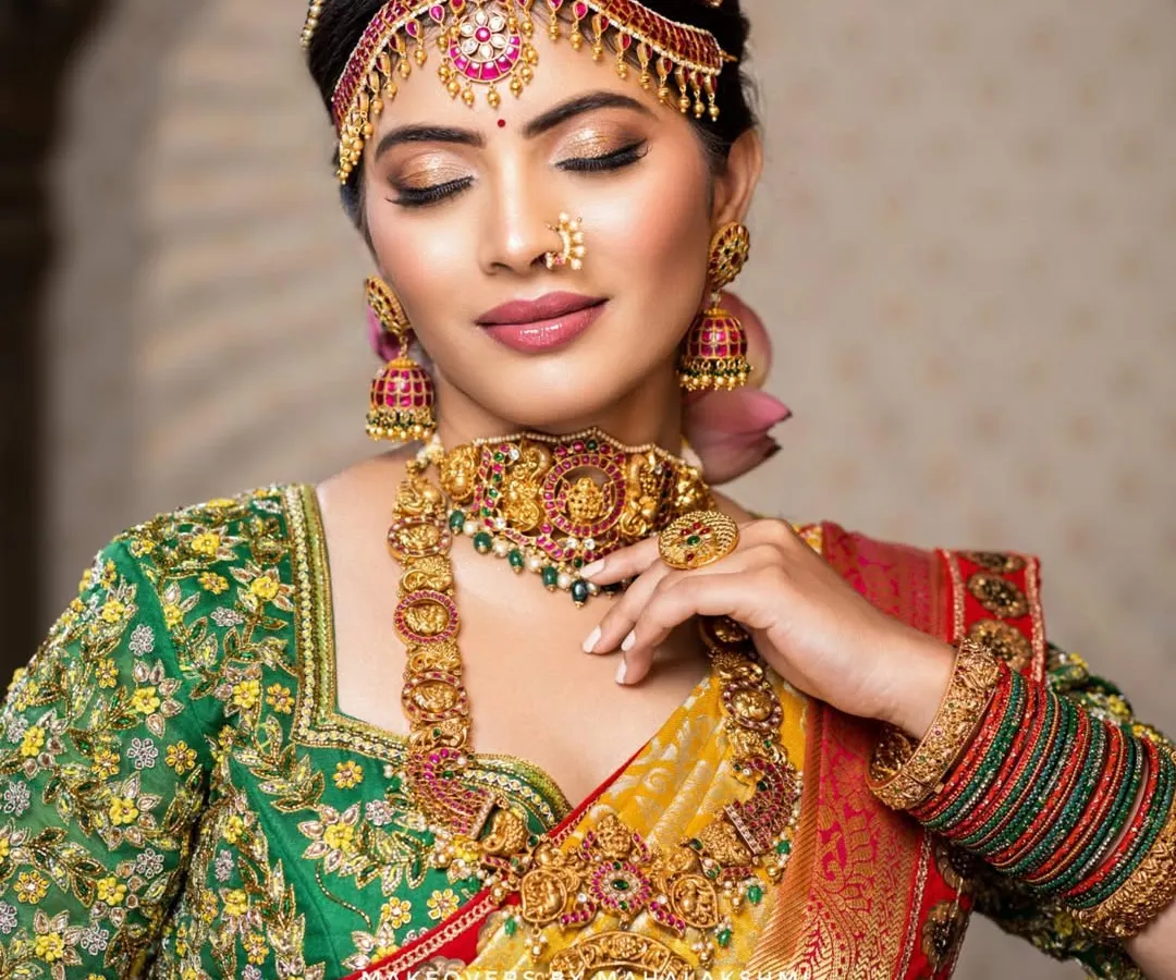 A complete South Indian bridal look, featuring a flawless, glowing base and soft glam eye makeup that complements the traditional gold jewelry and vibrant silk saree. This is a perfect example of the radiant and long-lasting bridal makeup I love to create.