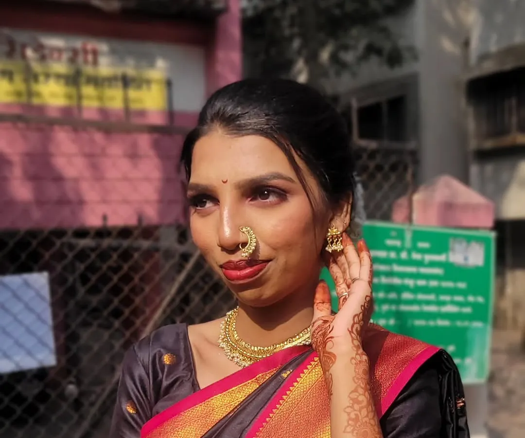 I love creating classic Maharashtrian traditional looks. This style features a warm, glowing base, defined eyes, a bold red lip, and is completed with traditional jewelry like the iconic *nath* (nose ring).