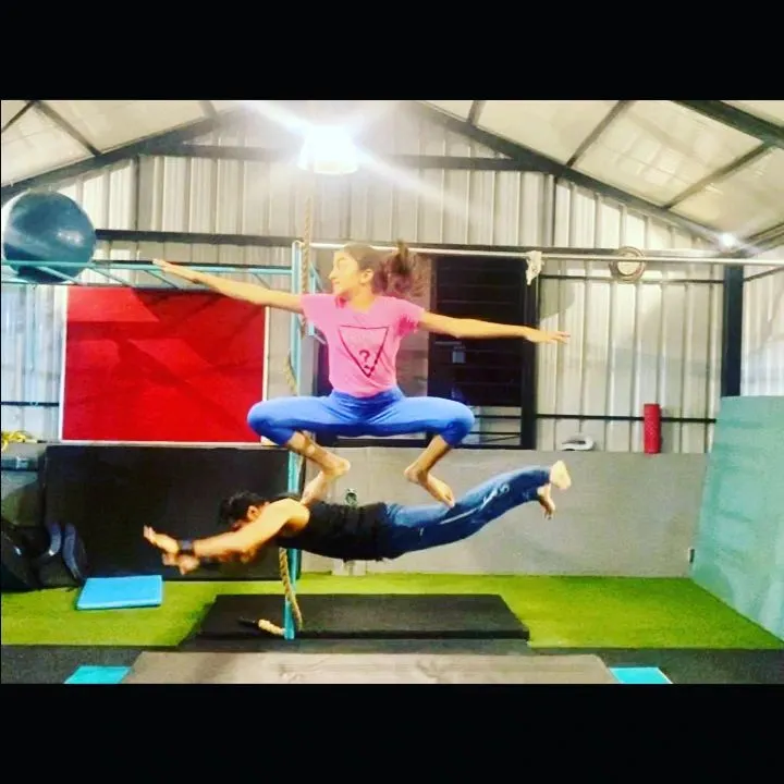 Partner acrobatics are a core part of my training. Here, I'm the base for a student performing a complex acro yoga pose, demonstrating the trust and strength we build together.