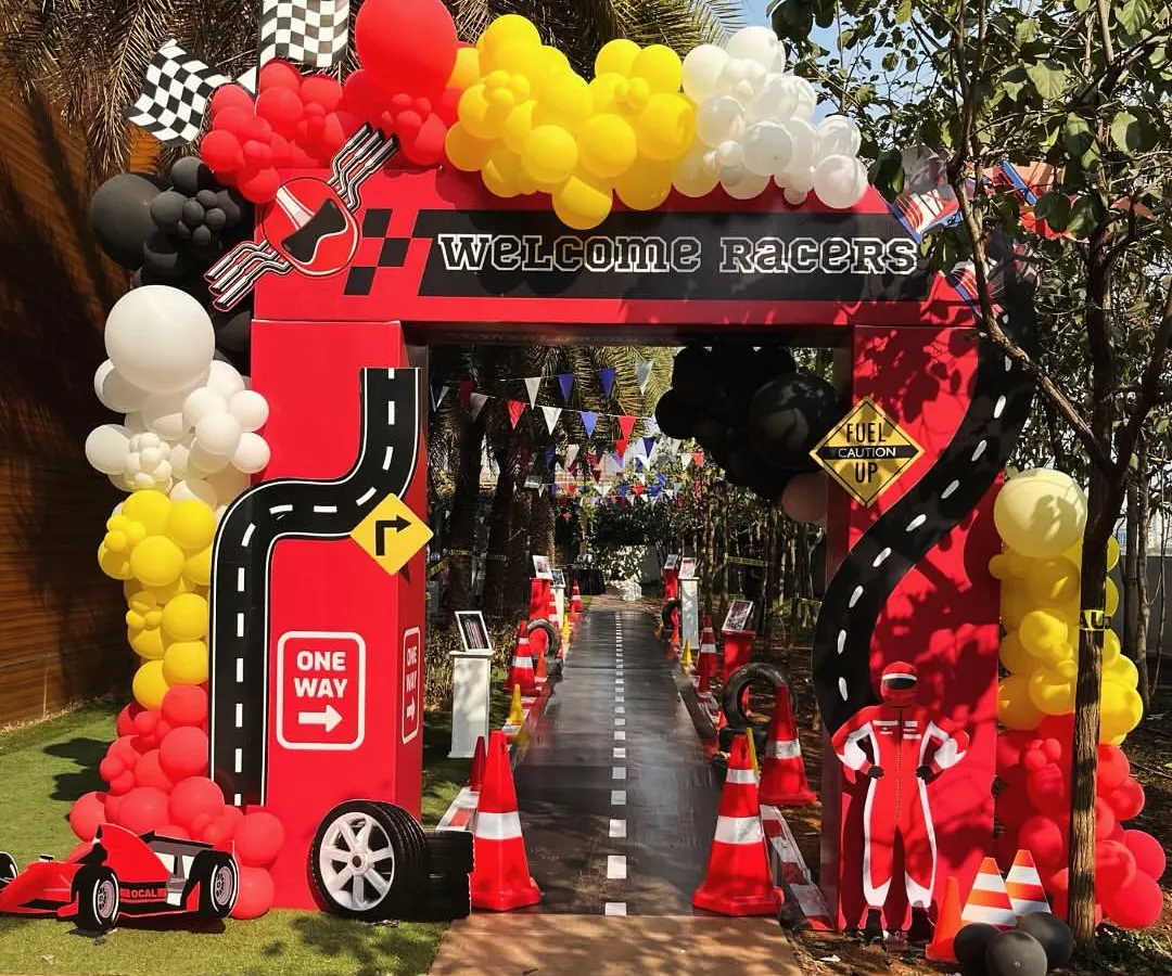 Welcome to the fast lane. This grand entrance arch for a Ferrari-themed birthday party sets the high-energy tone from the moment guests arrive, complete with a custom racetrack walkway and racing-inspired balloon garlands.