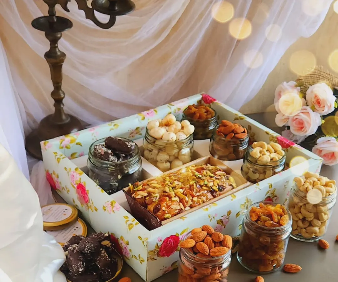 Our Lavish Tea Time Hamper is designed to impress. It features a beautiful floral tray filled with our signature Parsi Mawa Tea Cake, assorted premium nuts like cashews and almonds, and rich chocolate treats, making it a perfect gift for valued clients and partners.