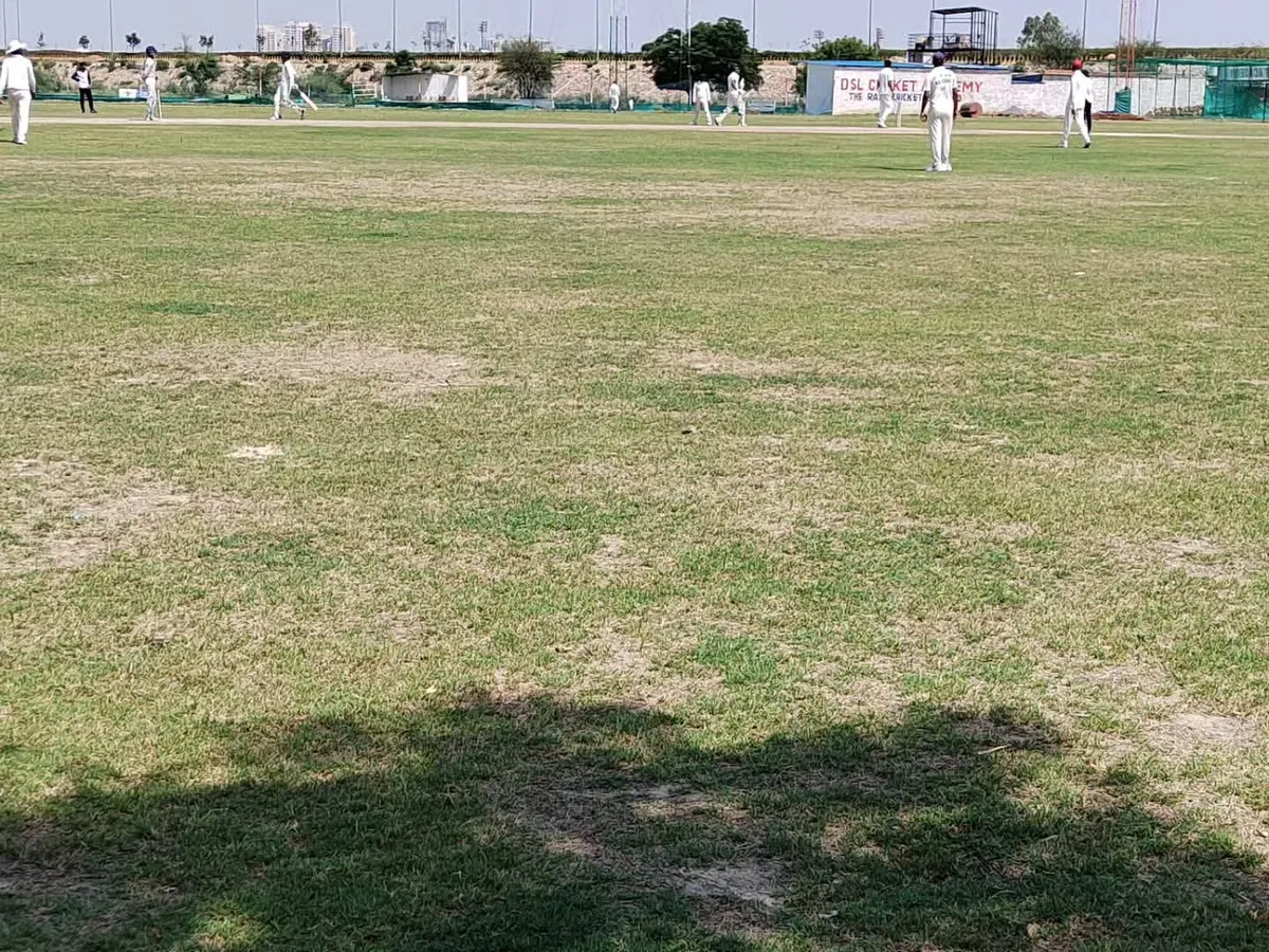 A view of our main cricket ground during a weekly practice match. We have a lush, well-maintained grass field to ensure you get experience in real match conditions, which is a core part of our residential program.