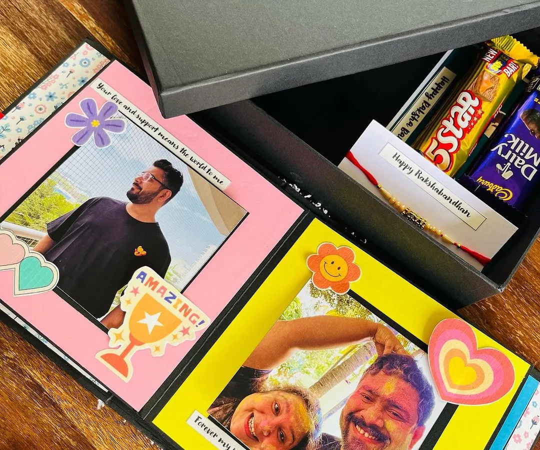 This is one of my favorite Rakhi hampers. It features a personalized scrapbook filled with childhood photos, a bar of chocolate, and a handwritten card, all presented in my signature gift box. It’s the perfect way to send love to your sibling.