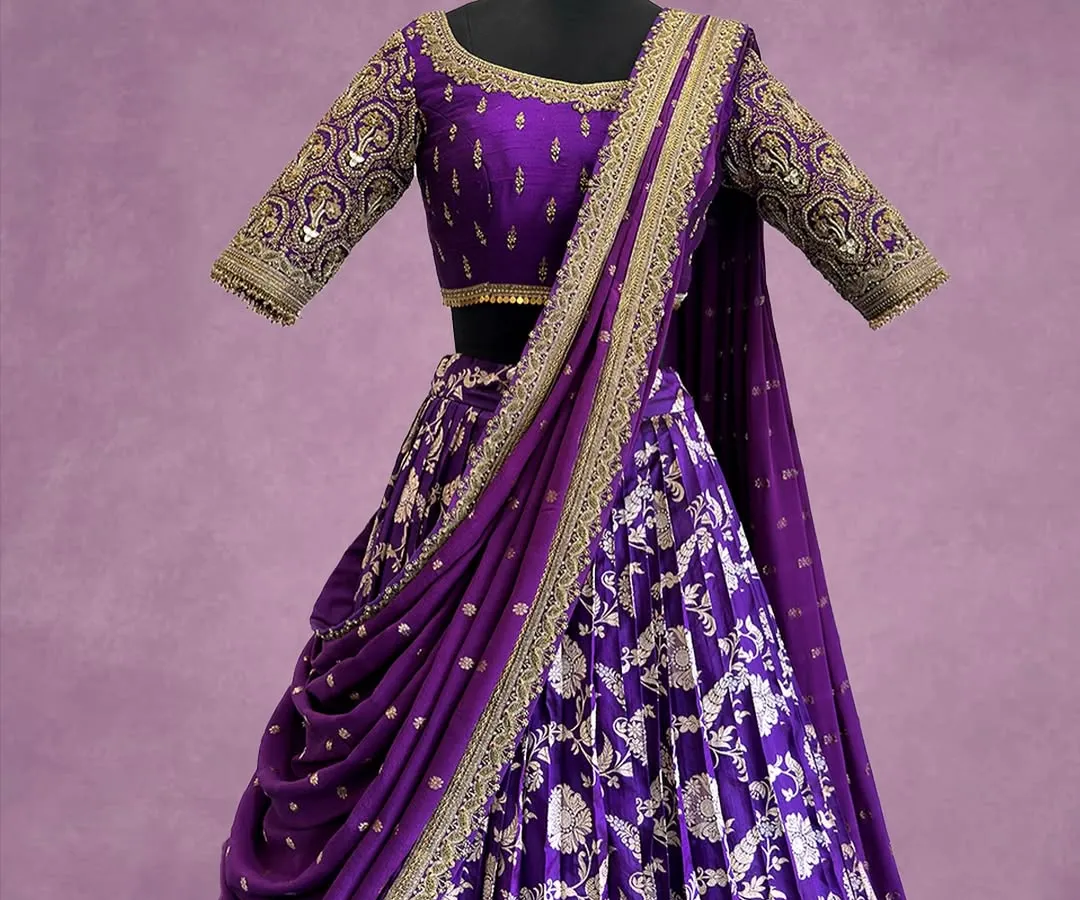 A symphony of royal purple and gold. This custom lehenga features intricate floral embroidery and a beautifully draped dupatta, designed to make a grand statement at any celebration.