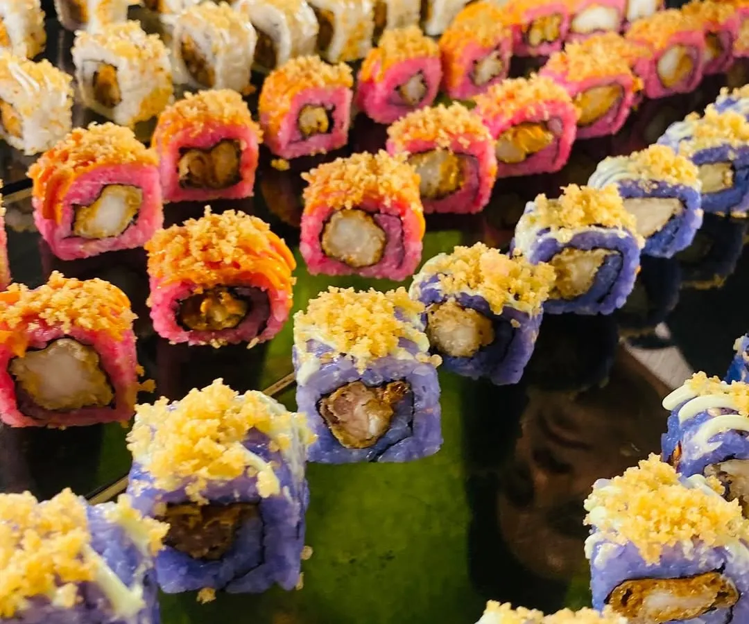 A vibrant platter of assorted sushi, including colorful prawn tempura rolls. My interactive sushi stations bring a taste of authentic Japanese cuisine to your event, prepared fresh by skilled chefs.
