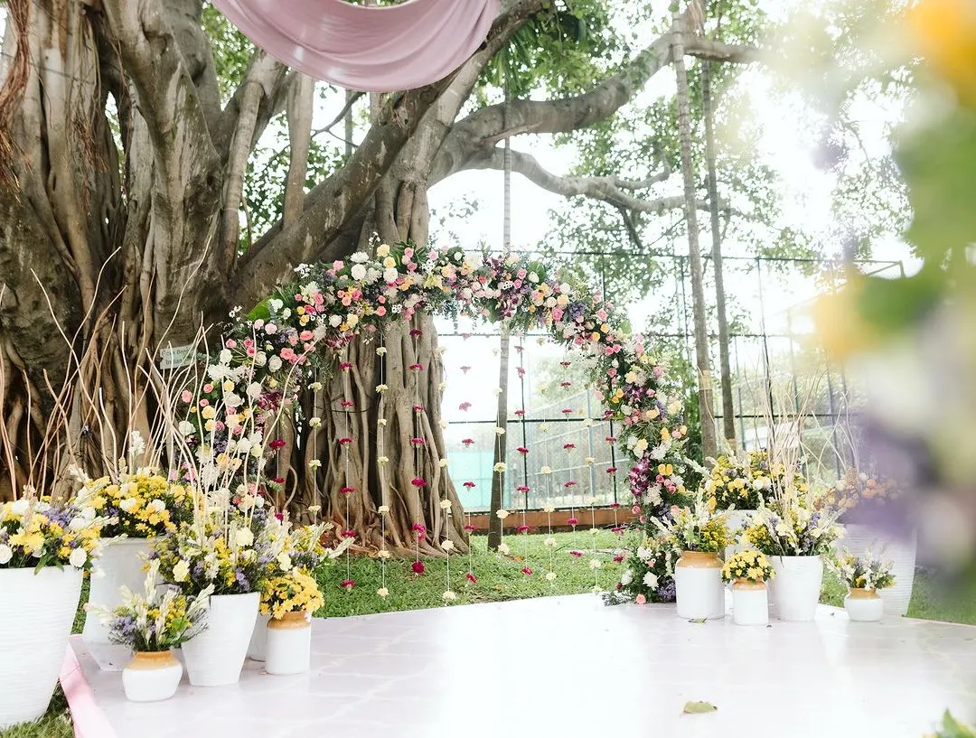 I love using nature as my canvas. For this Haldi, we built a dreamy floral arch right under a magnificent banyan tree, letting the decor feel like a natural extension of the beautiful surroundings.