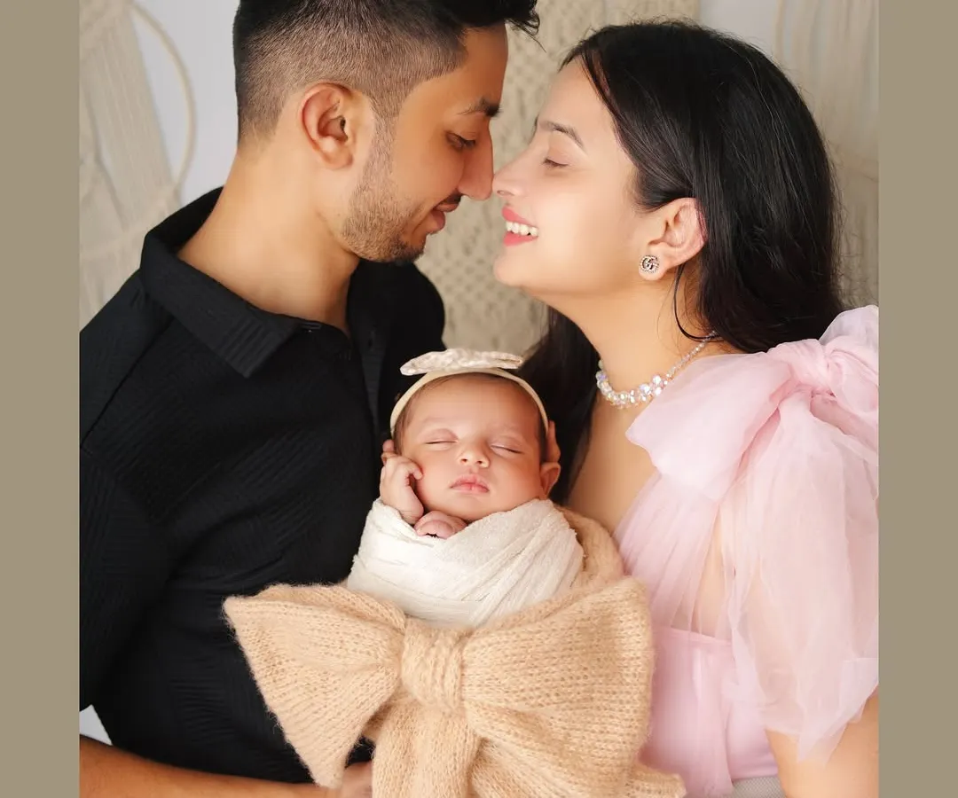 There's nothing more special than a family's first portrait. I captured this beautiful moment with the new parents adoring their sleeping newborn, who is wrapped snugly in a bow-adorned swaddle.