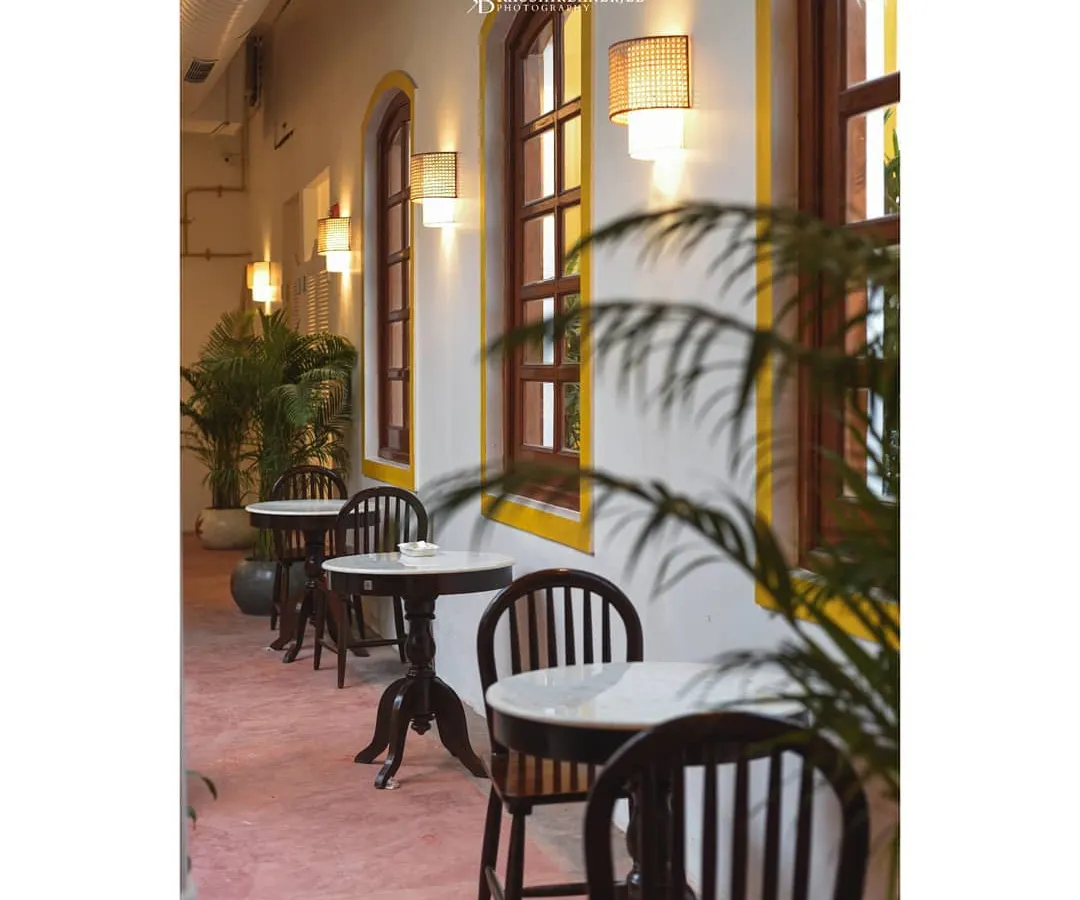 A bright, welcoming cafe corridor at Colocal. This shot emphasizes the clean lines, natural light from the large windows, and the airy atmosphere, perfect for showcasing a daytime spot.